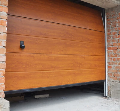 Professional garage door technician realigning bent vertical tracks and adjusting hardware with precision tools, showing expert track straightening and off-track door reset service for smooth garage door operation in Louisville homes
